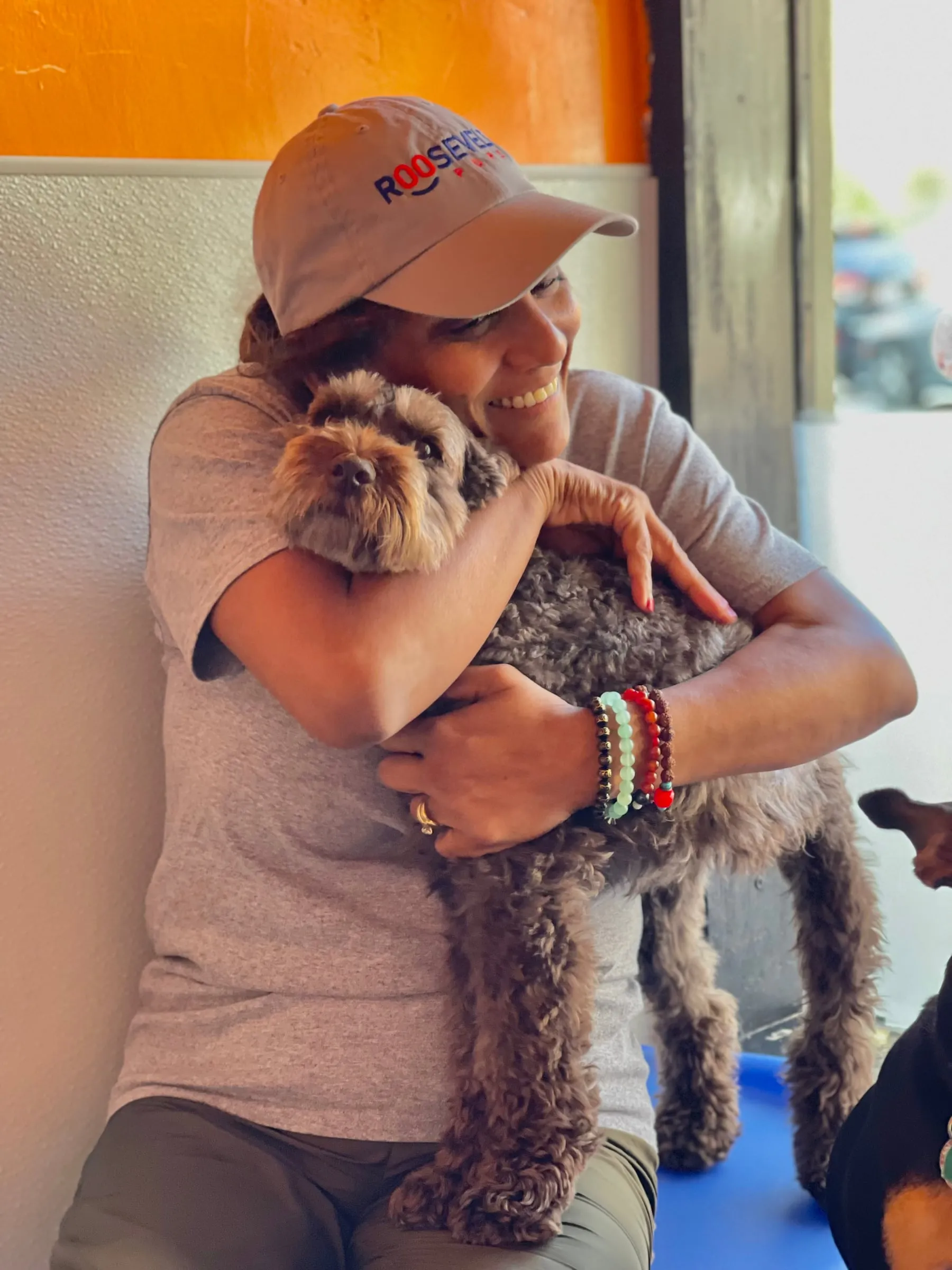 Nema, our founder, hugging a fluffy grey pup